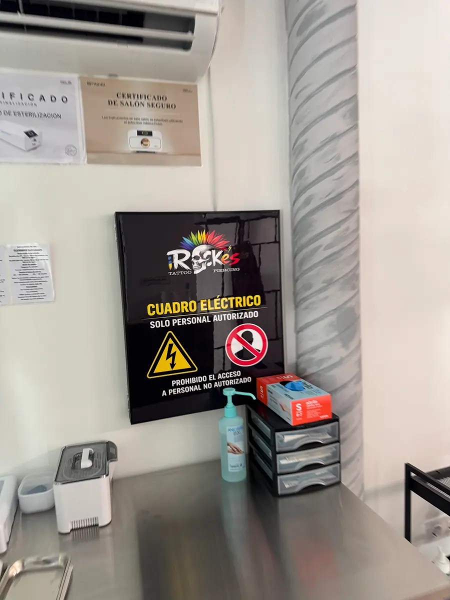 La zona de esterilización del estudio: certificado en la pared, cubeta de ultrasonidos, guantes.